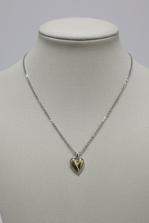 Necklace with a heart pendant on a mannequin bust against a plain background