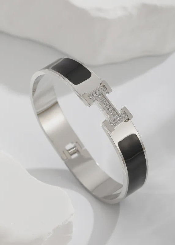 Silver bracelet with black accents on a white background