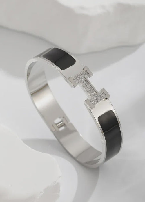 Silver bracelet with black accents on a white background