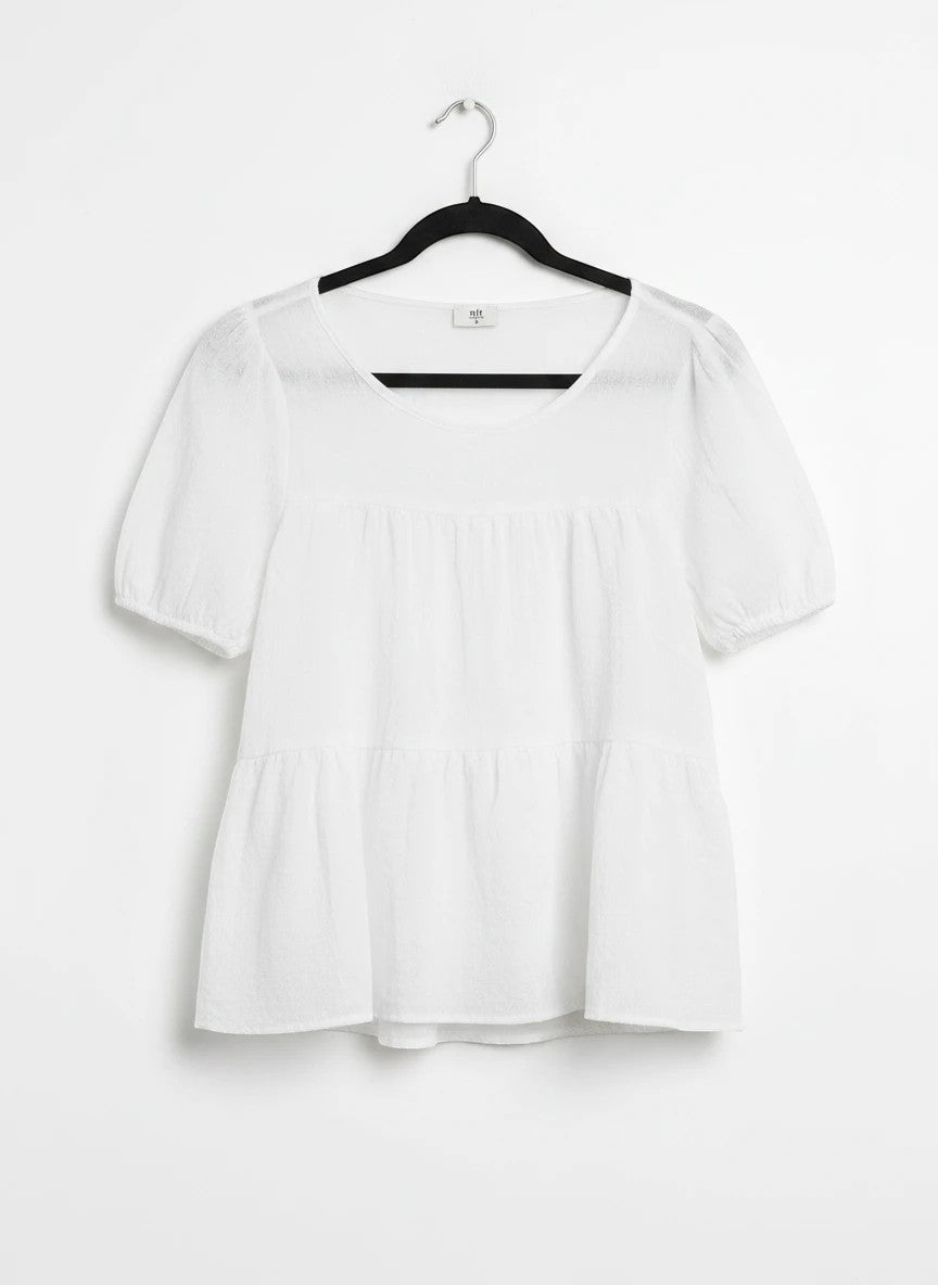 Chandeliers Boutique ny white tiered top with short puffy sleeves in a cotton-polyester blend on a black hanger